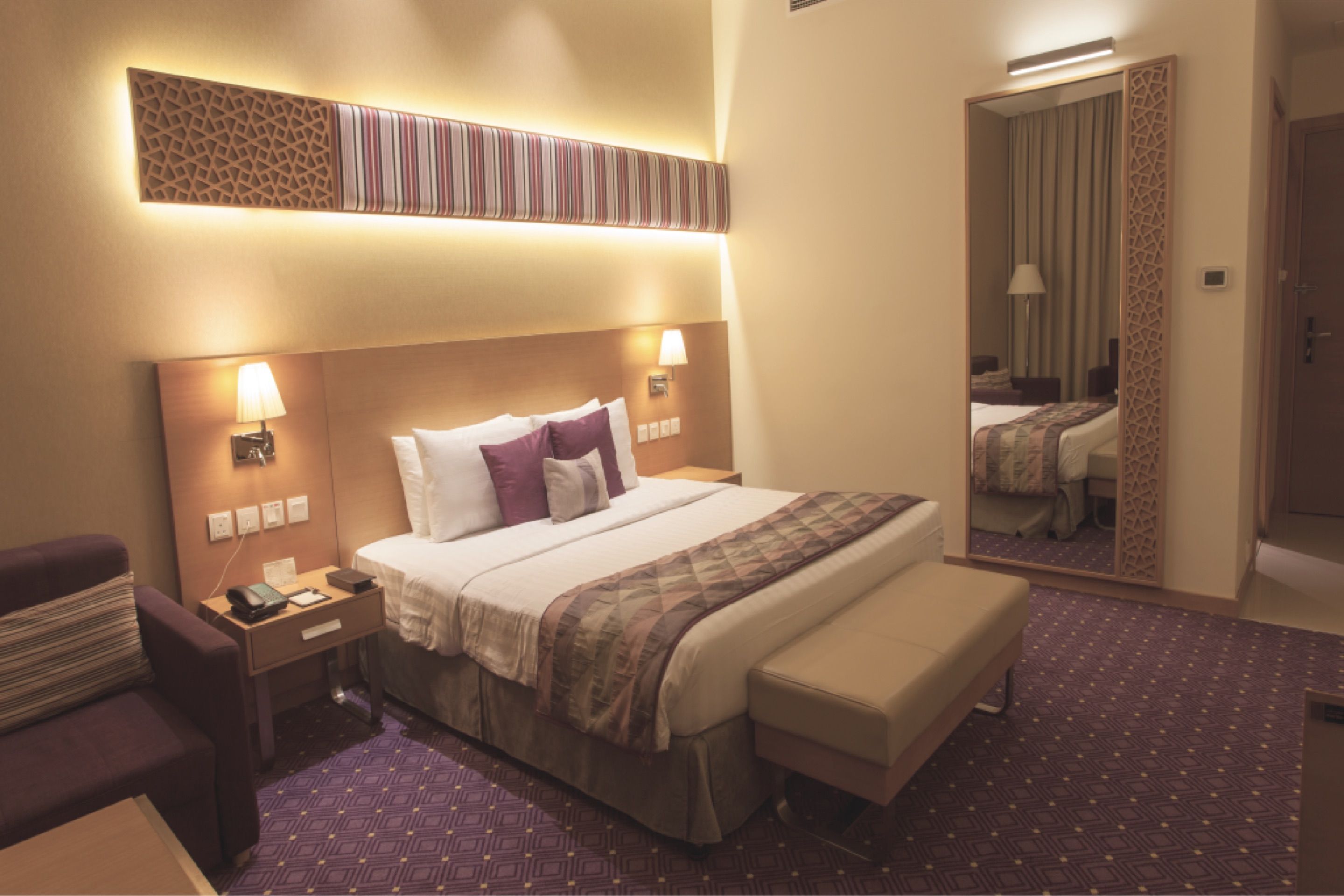 Interior de uma das suítes do Taj Hotel, com cama de casal e iluminação quente