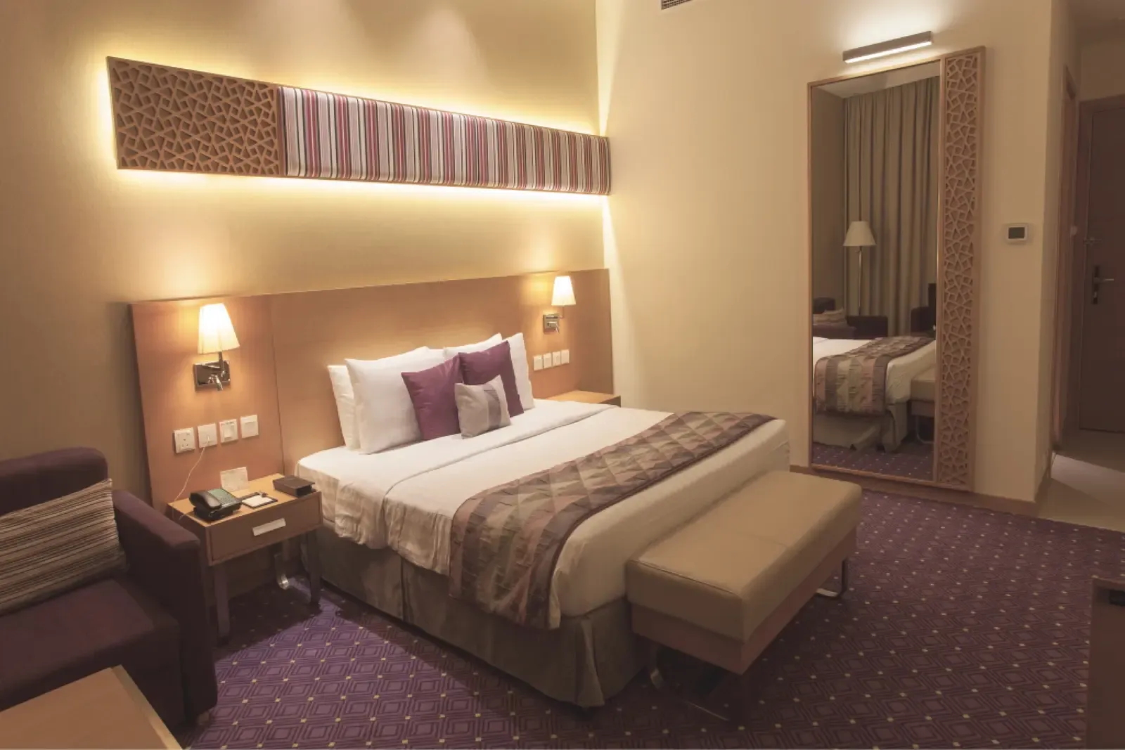 Interior de uma das suítes do Taj Hotel, com cama de casal e iluminação quente